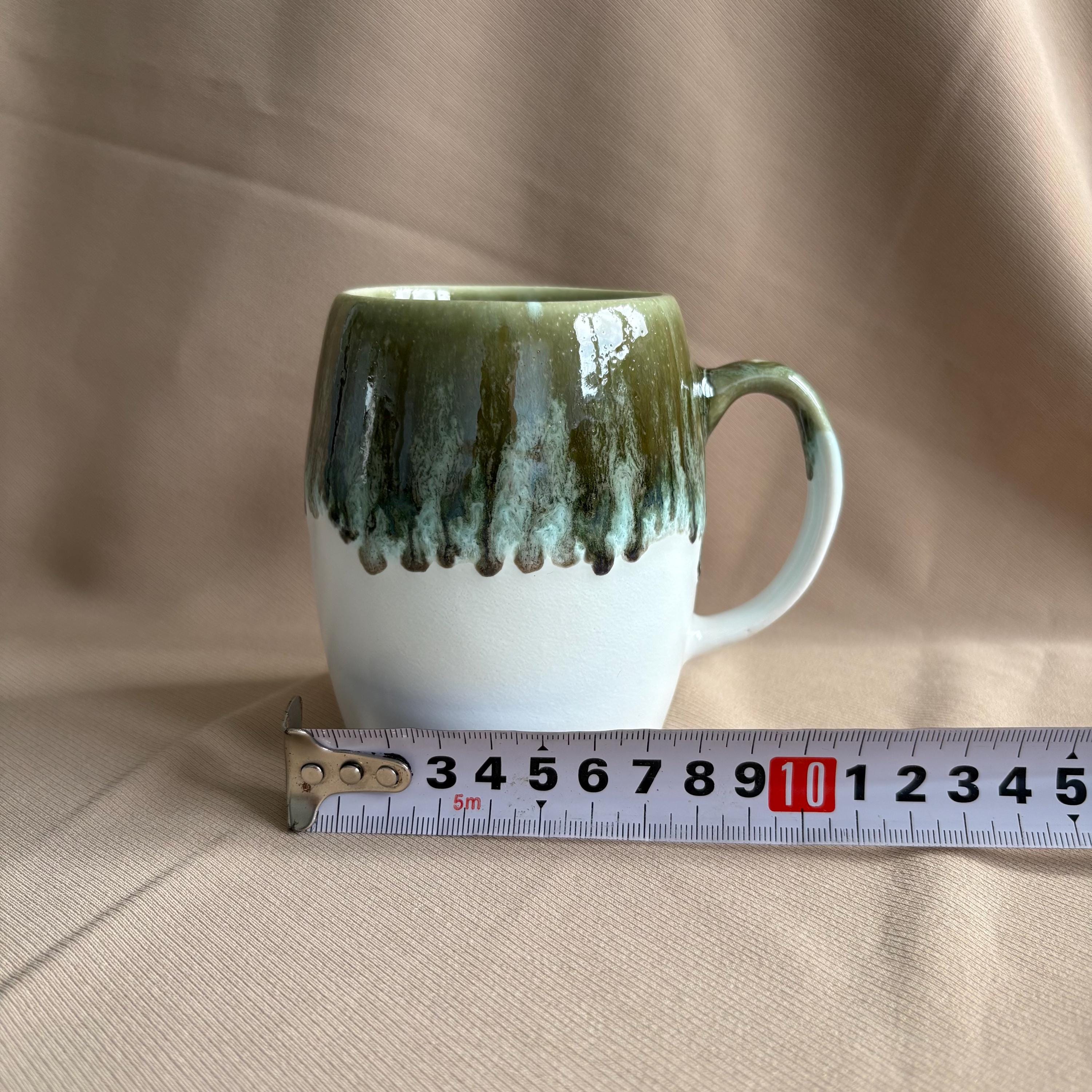 Grey & White Drip Glaze Stoneware Mug next to a measuring tape for size reference.